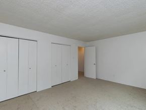 Portland apartment for rent - A room with white walls and a carpeted floor with three doors.