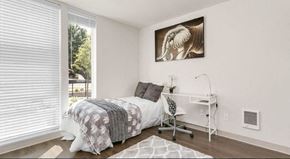 Seattle apartment for rent - a bedroom with a bed and a desk and a window