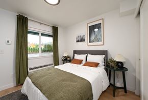 Bellevue apartment for rent - A bedroom with a large bed and a window with green curtains.