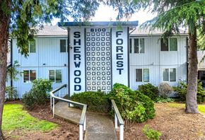 Lakewood apartment for rent - A white building with a sign that says Sherwood Forest.