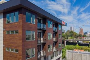 Portland apartment for rent - A modern building with wooden panels and balconies overlooks a cityscape.