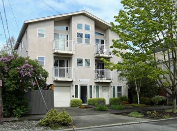 Seattle apartment for rent - a white apartment building with balconies and trees