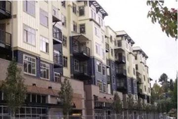 Seattle apartment for rent - a building with many balconies and a fence in front of it