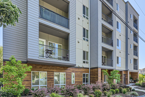 Everett apartment for rent - A modern apartment building with balconies and a well-maintained garden in front.