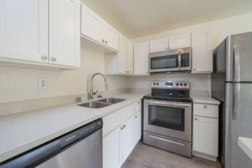 Tacoma apartment for rent - A kitchen with white cabinets and stainless steel appliances.