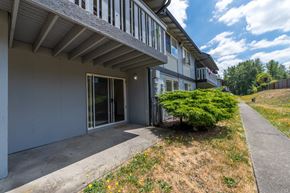 Tacoma apartment for rent - A building with a balcony and a bush in front.