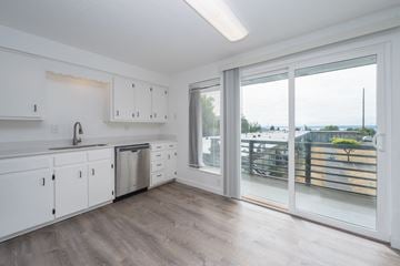 Federal Way apartment for rent - A kitchen with white cabinets and a wooden floor.