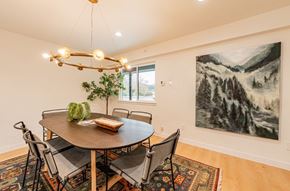 Bellevue apartment for rent - A dining room with a round table and chairs, a potted plant, and a large landscape painting on the wall.