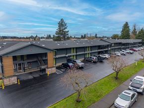 Centralia apartment for rent - A parking lot with cars and a building in the background.