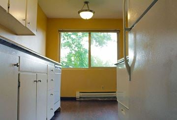 Seattle apartment for rent - a kitchen with a large window and white cabinets