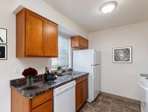 St Helens apartment for rent - A kitchen with brown cabinets and a white refrigerator.