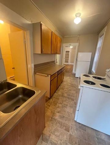 Spokane apartment for rent - A kitchen with a white refrigerator and a stove top oven.
