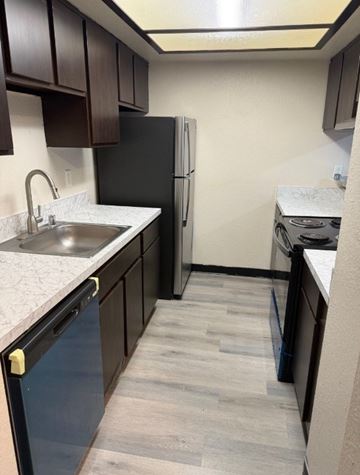 Seattle apartment for rent - A kitchen with a black fridge and a black dishwasher.