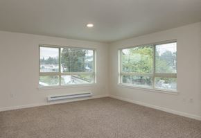 Seattle apartment for rent - an empty living room with two windows and carpet