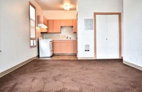 Seattle apartment for rent - an empty living room with a refrigerator and a kitchen