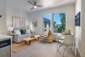 Portland apartment for rent - A living room with a grey sofa, a wooden coffee table, and a white chair.