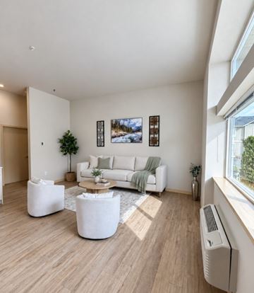 Wenatchee apartment for rent - A living room with a white couch, a green blanket, and a white coffee table.
