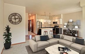 Wenatchee apartment for rent - A living room with a couch, a coffee table, and a large clock on the wall.