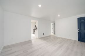 Lakewood apartment for rent - A spacious room with a dark blue door and light wooden flooring.