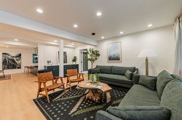 Bellevue apartment for rent - A living room with a green couch and wooden chairs.
