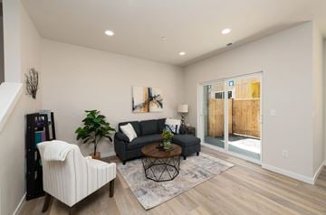 Marysville apartment for rent - A living room with a white chair, a grey couch, a coffee table, and a painting on the wall.
