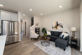 Marysville apartment for rent - A modern kitchen with a stainless steel refrigerator and a grey sofa with a white throw pillow.