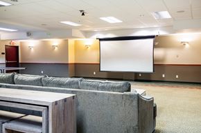 Gresham apartment for rent - A conference room with a white screen and grey couches.