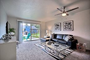 Everett apartment for rent - spacious living room with couch and glass coffee table and sliding glass door to patio