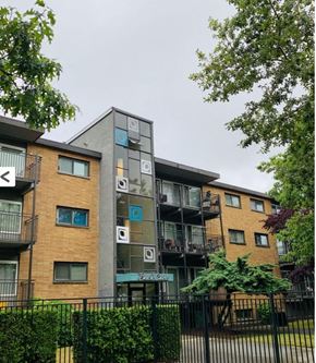 Seattle apartment for rent - A modern apartment building with balconies and a black fence in front.