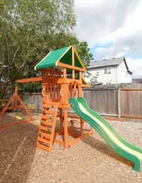 St Helens apartment for rent - A wooden playground structure with a green roof and a green slide.