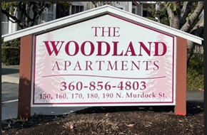 Sedro Woolley apartment for rent - a sign for the woodland apartments on the side of the road