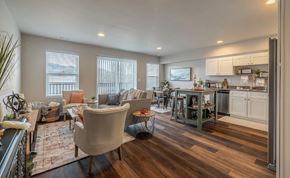 East Wenatchee apartment for rent - A well-lit living room with a kitchen area in the background.