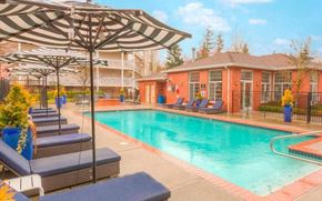 Mukilteo apartment for rent - a swimming pool with chairs and umbrellas near a building