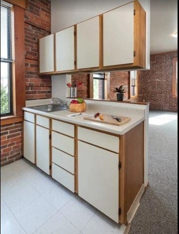 Seattle apartment for rent - A kitchen with white cabinets and a wooden island.