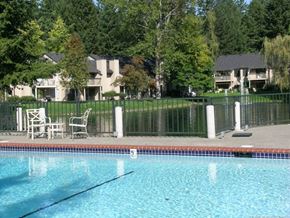 Federal Way apartment for rent - a swimming pool with chairs and a fence around it