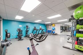 Quincy apartment for rent - a gym with cardio equipment and weights in a building