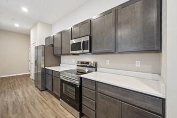 Delaware townhouse for rent - A modern kitchen with dark wood cabinets and stainless steel appliances.
