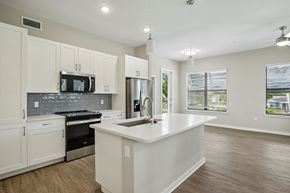 Bonita Springs apartment for rent - A kitchen with white cabinets and a stainless steel refrigerator.