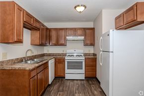 Springfield apartment for rent - A kitchen with brown cabinets and white appliances.