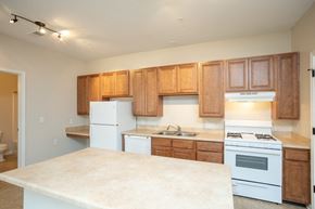 Galloway apartment for rent - A kitchen with white appliances and wooden cabinets.