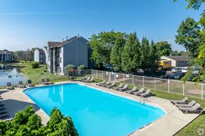 Hilliard apartment for rent - A swimming pool surrounded by lawn chairs and trees.