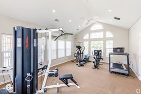 South Park Township condo for rent - A spacious home gym with a variety of equipment including a treadmill, exercise bike, and weight machine.