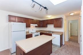 Butler apartment for rent - A kitchen with brown cabinets and a white fridge.