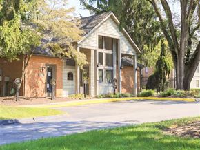 Blacklick apartment for rent - A building with a white roof and a large glass window is surrounded by trees.