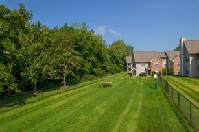 Columbus apartment for rent - A grassy field with a fence and a building in the background.