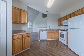Canonsburg condo for rent - A kitchen with wooden cabinets and white appliances.