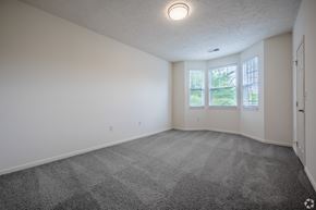 Canonsburg condo for rent - A spacious room with a grey carpet and white walls.
