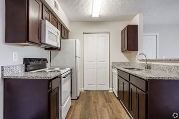 Hilliard apartment for rent - A kitchen with white appliances and brown cabinets.