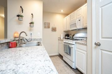 Columbus apartment for rent - A kitchen with white cabinets and a marble countertop.