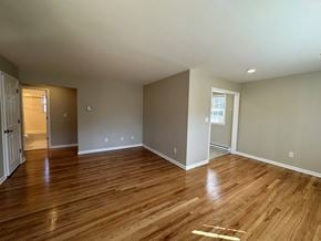 New Milford apartment for rent - a living room with wood floors and a door to a bathroom